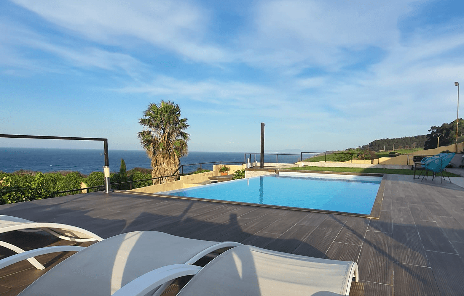 Piscina infinity con jardín abierto y vistas al mar